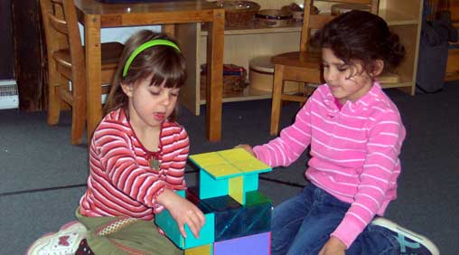 girls playing using montessori magnetic tiles